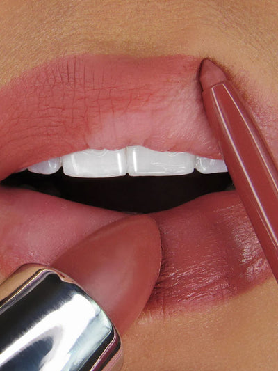 Meow -- close up of model lips applying mauve lipstick and lip liner to top and bottom lip