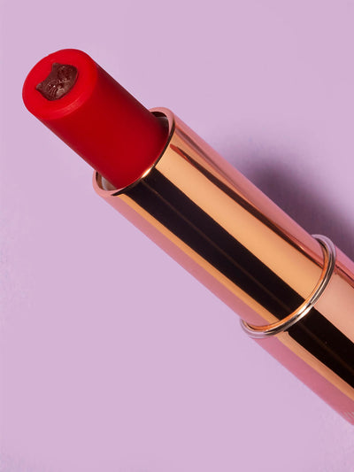 Fur Ever -- close up of purrfect pout sheer red lipstick flat lay on purple background