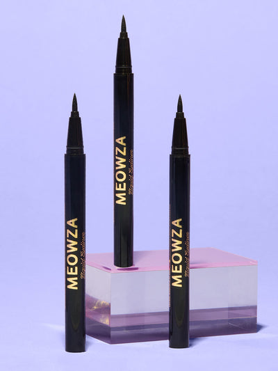 Black -- meowza liquid eyeliner standing on glass surface with purple background