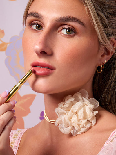 love letter -- close up of blonde model applying skinny plump demi matte plumping lipstick