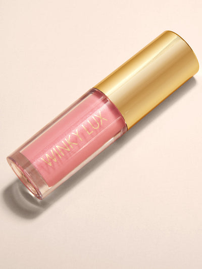 Passion -- flat lay of sheer pink tinted lip oil with cap on