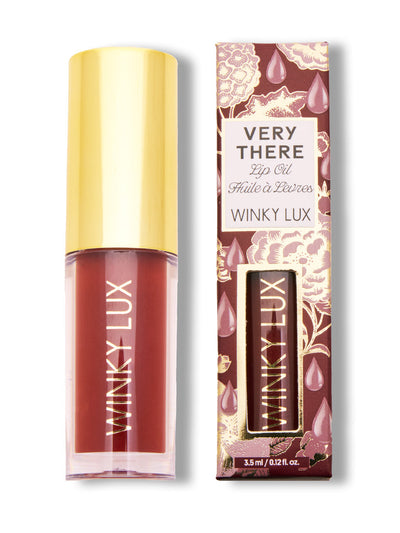 Enchanted -- tinted mauve lip oil next to box on white background