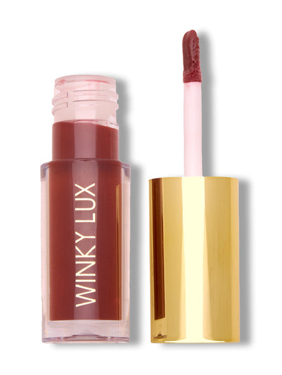 Enchanted -- mauve tinted lip oil with cap off on white background