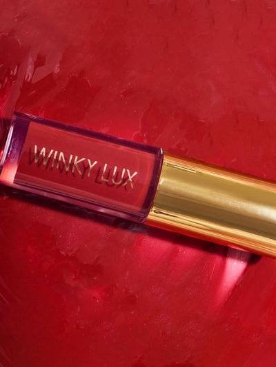 enchanted -- close up of red lip oil component lying on top of lip oil goop