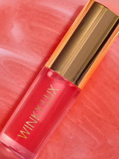 peach whisper -- stylized shot of peach lip oil component on top of lip oil goop