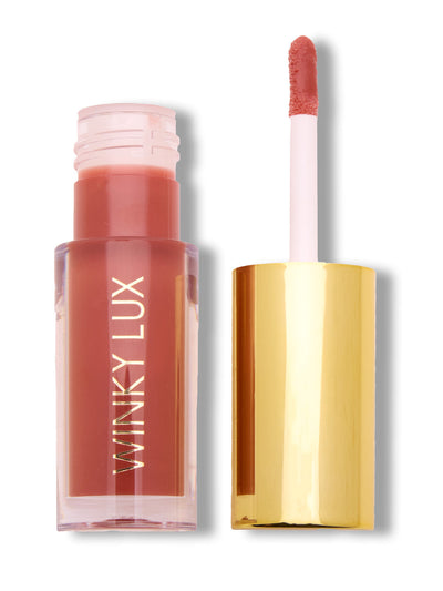 Swoon -- pink tinted lip oil with cap off on white background