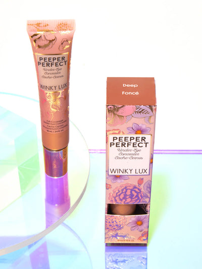 Deep -- peeper perfect under eye concealer next to box with shiny props