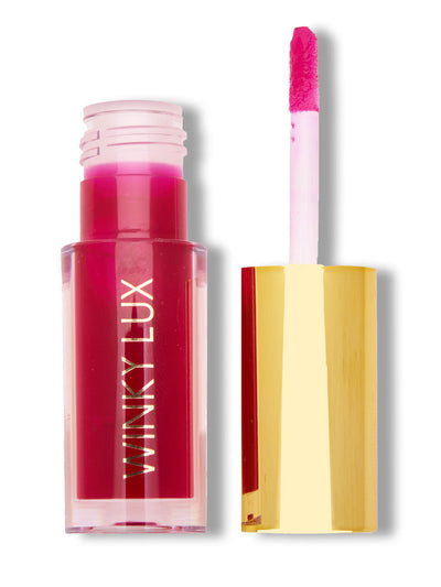 crave -- deep pink lip oil with cap next to on white background