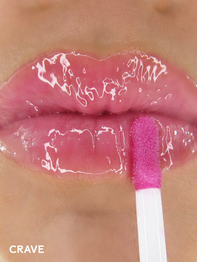 crave -- close up of applicator applying deep pink lip oil to lips