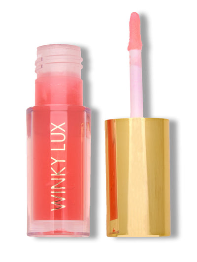 peach whisper -- peach lip oil with cap off on white background
